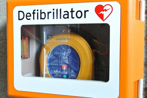 Wall-mounted AED cabinet with a defibrillator inside