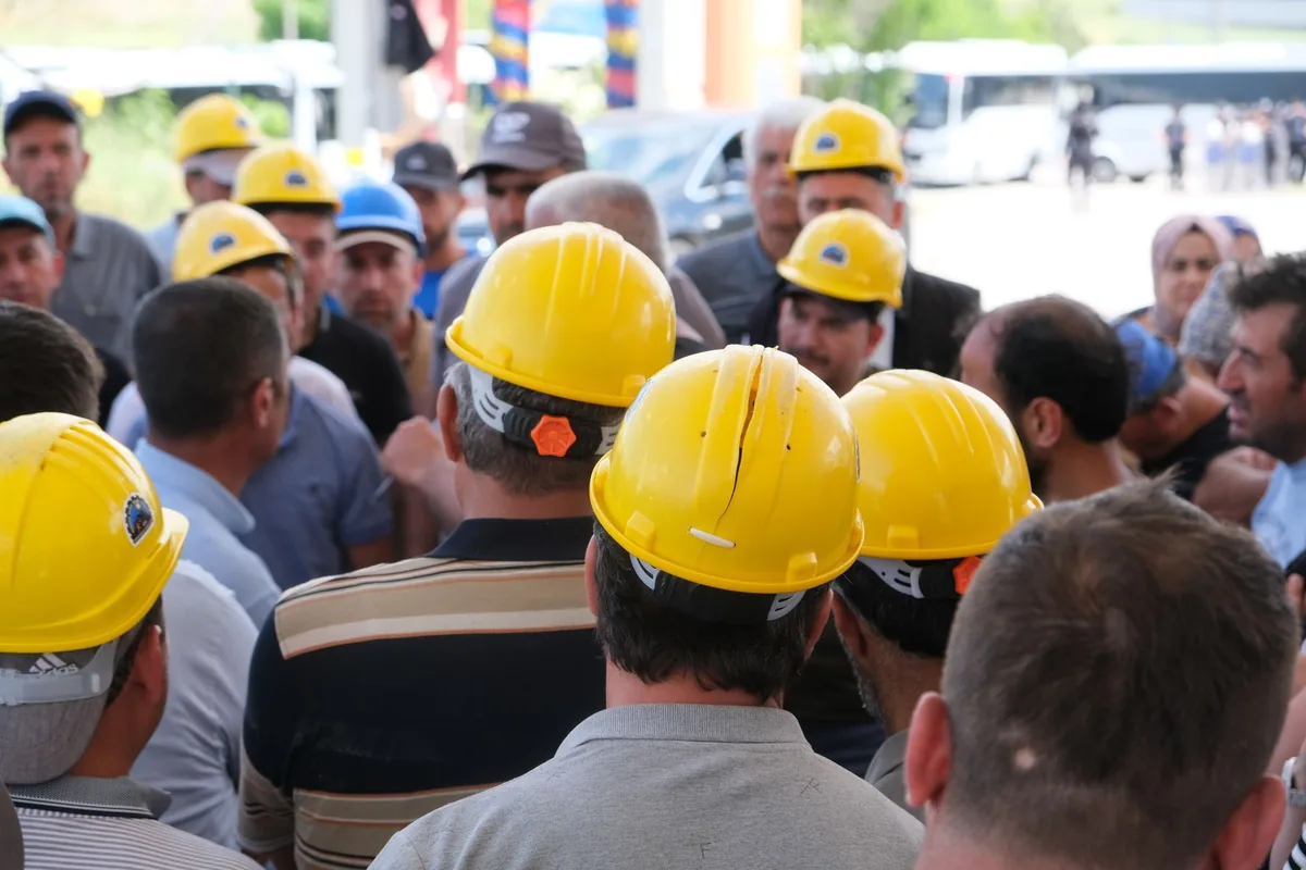 Crew in yellow hard hats gathered for a safety briefing